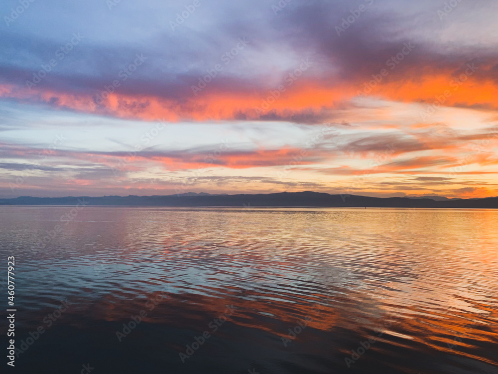 Fantastic colors of the sunset, colorful clouds and sky reflection on the surface of the water, magic lake, natural background, wallpaper