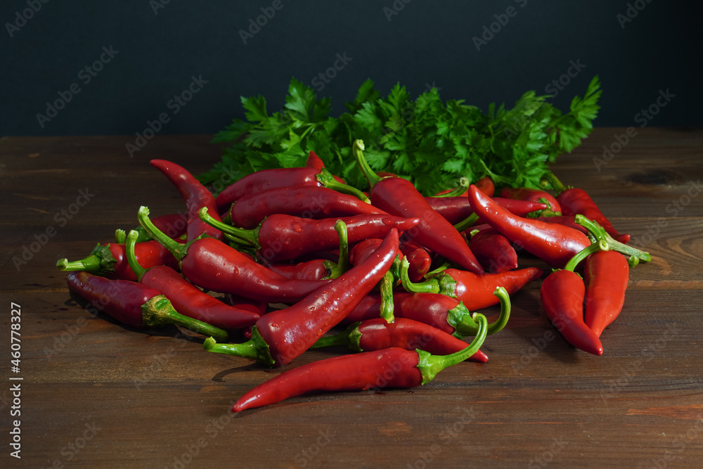 Red chili peppers and parsley on wooden table