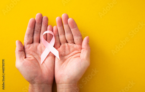 Woman hands and supporting Pink ribbon symbol of breast cancer. Breast Cancer concept