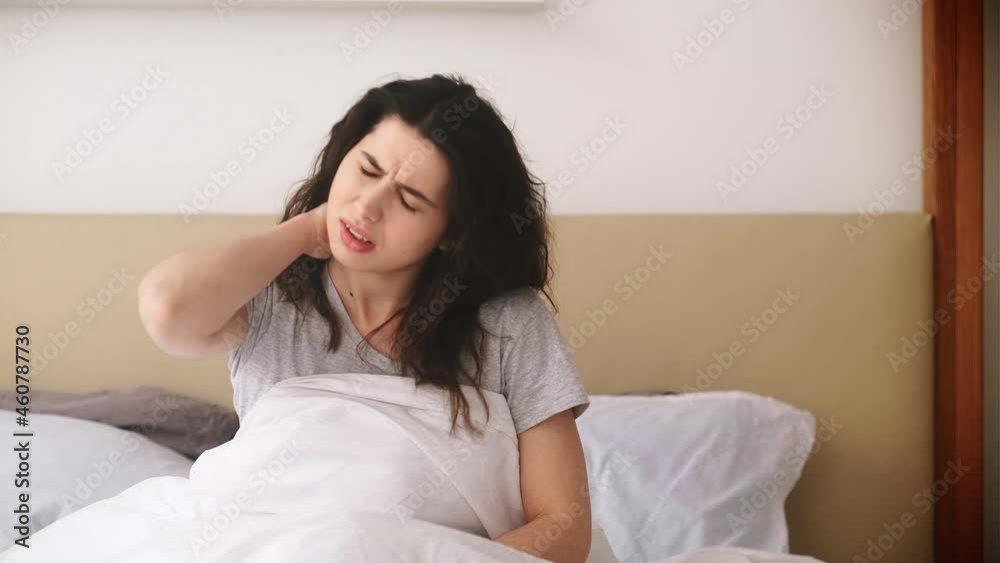 Neck pain. Uncomfortable bed. Orthopedic mattress. Posture problems. Frustrated young woman suffering from stiff back ache spasm discomfort after bad sleep at light bedroom.