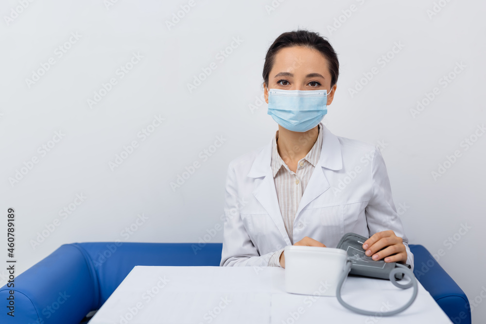doctor in white coat and medical mask holding tonometer doctor in white coat and medical mask holding tonometer