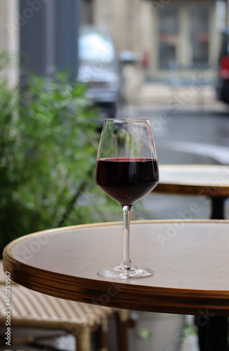 A glass of red wine on the summer terrace of a Parisian restaurant