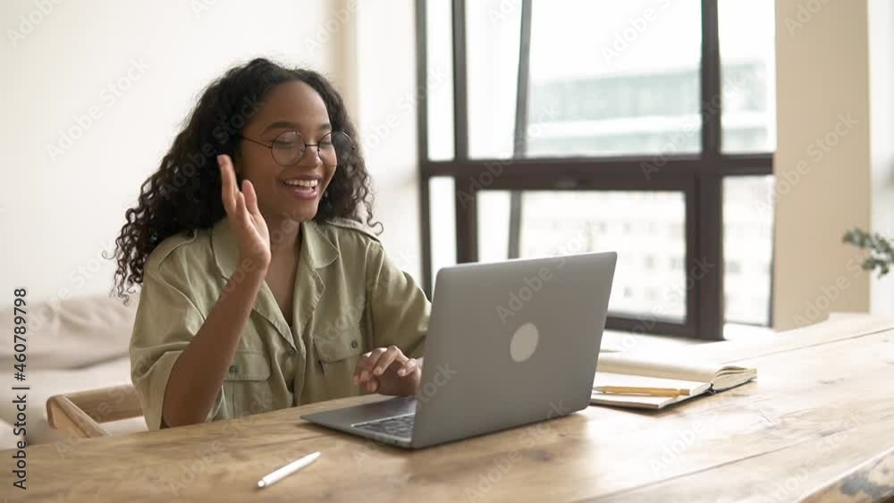 Home people remote: young businesswoman waves and talks in front of laptop at table office epspb. Closeup view of beautiful American African woman waves hand in front of computer screen and looks with Home people remote: young businesswoman waves and talks in front of laptop at table office epspb. Closeup view of beautiful American African woman waves hand in front of computer screen and looks with