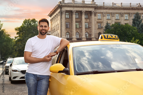 Handsome taxi driver near car on city street