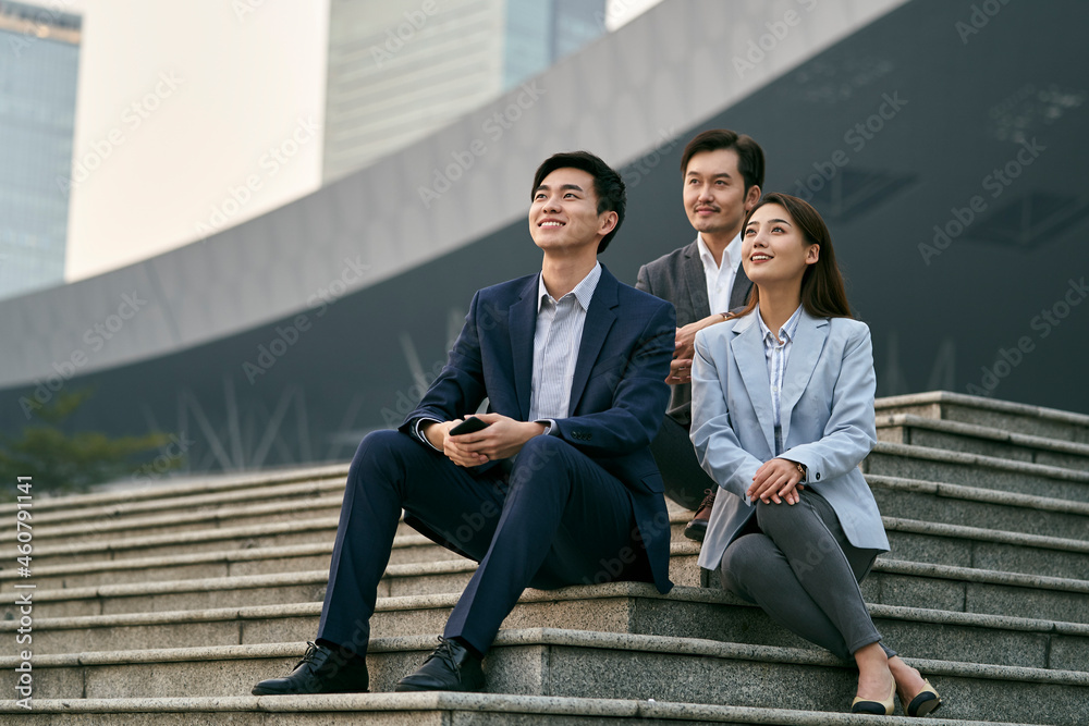 team of three asian corporate executives relaxing outdoors team of three asian corporate executives relaxing outdoors
