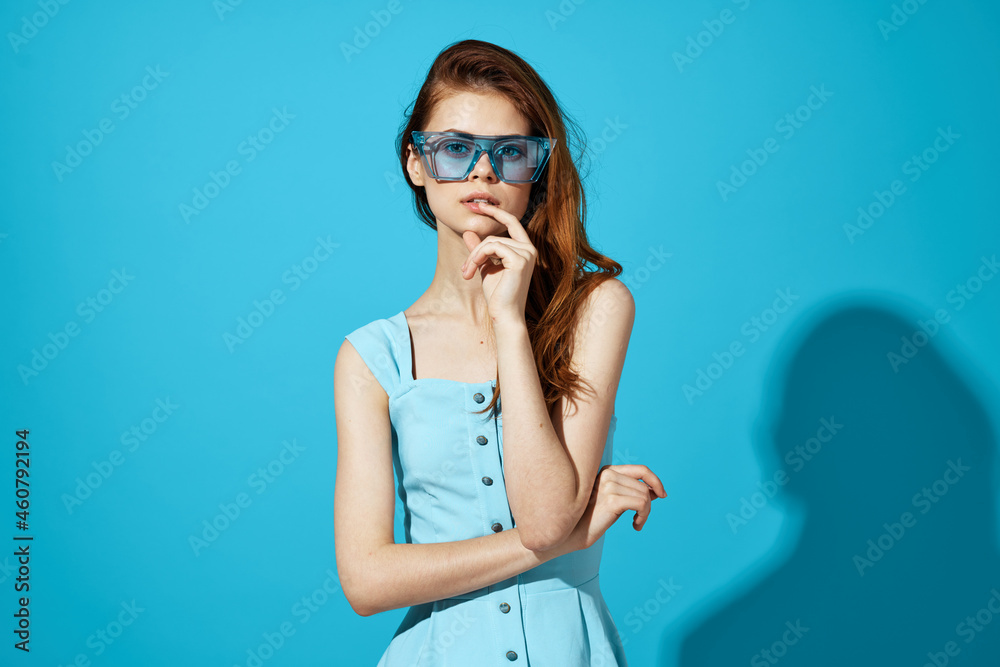 woman in a blue dress with phone in hand posing Studio fun