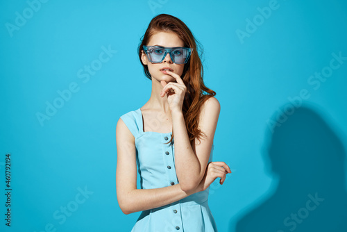 woman in a blue dress with phone in hand posing Studio fun