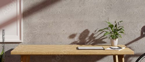 Closeup Modern minimalist workplace with copy space on a wooden table against grey cement wall