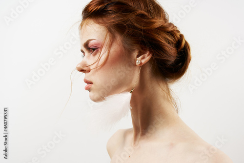 woman with bare shoulders bright makeup jewelry earrings close-up