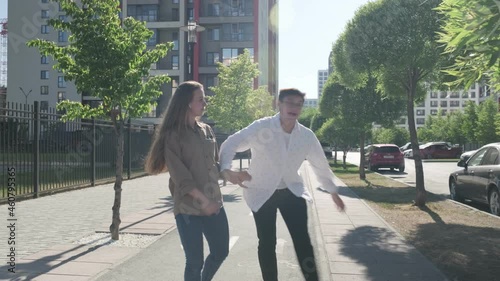 Street dance. Young couple dancing in the street. The guy and the girl move rhythmically. They dance and smile. In a new area. Stylish guy and girl.