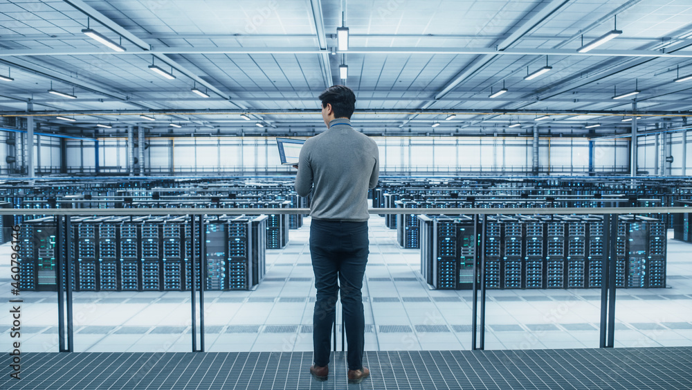 Data Center Engineer Using Laptop Computer. Server Farm Cloud Computing Specialist Facility with Asian Male System Administrator Working with Data Protection Network for Cyber Security. Data Center Engineer Using Laptop Computer. Server Farm Cloud Computing Specialist Facility with Asian Male System Administrator Working with Data Protection Network for Cyber Security.