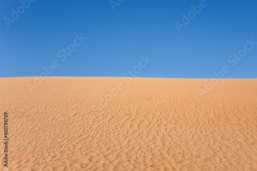 Ripple sand dunes and blue sky background. Desert landscape  sandy waves. Nature.