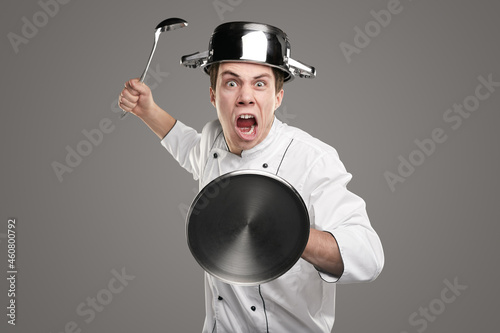 Angry chef with kitchen utensils photo