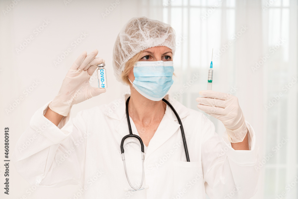 Doctor with mask and syringe is ready to administer the vaccine against covid 19 Doctor with mask and syringe is ready to administer the vaccine against covid 19