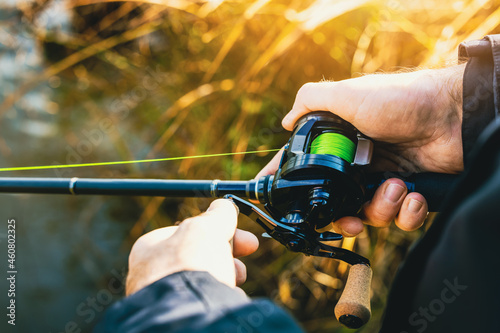 Canvastavla fishing rod with multiplier reel and green braided line in angler hands