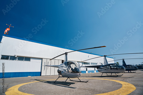 Choppers parked on helipad at metal hangar photo