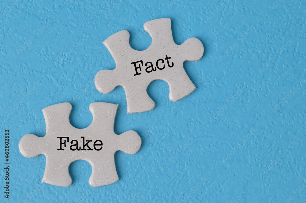 Obraz premium Jigsaw puzzle with text FACT and FAKE isolated on a blue background