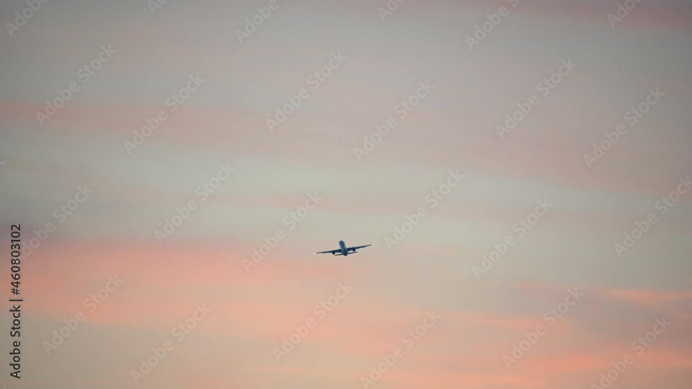 Large passenger airplane taking off and ascending against colorful sunset sky. Aircraft departure. Plane leaving and flying at sunset. Static shot, real time Large passenger airplane taking off and ascending against colorful sunset sky. Aircraft departure. Plane leaving and flying at sunset. Static shot, real time