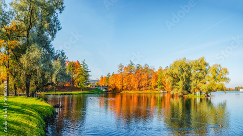 Fototapeta Naklejka Na Ścianę i Meble -  Bright autumn landscape with State Museum Reserve Gatchina. Sunny panoramic autumn view of the park, blue lake and Great Palace in the shore.
