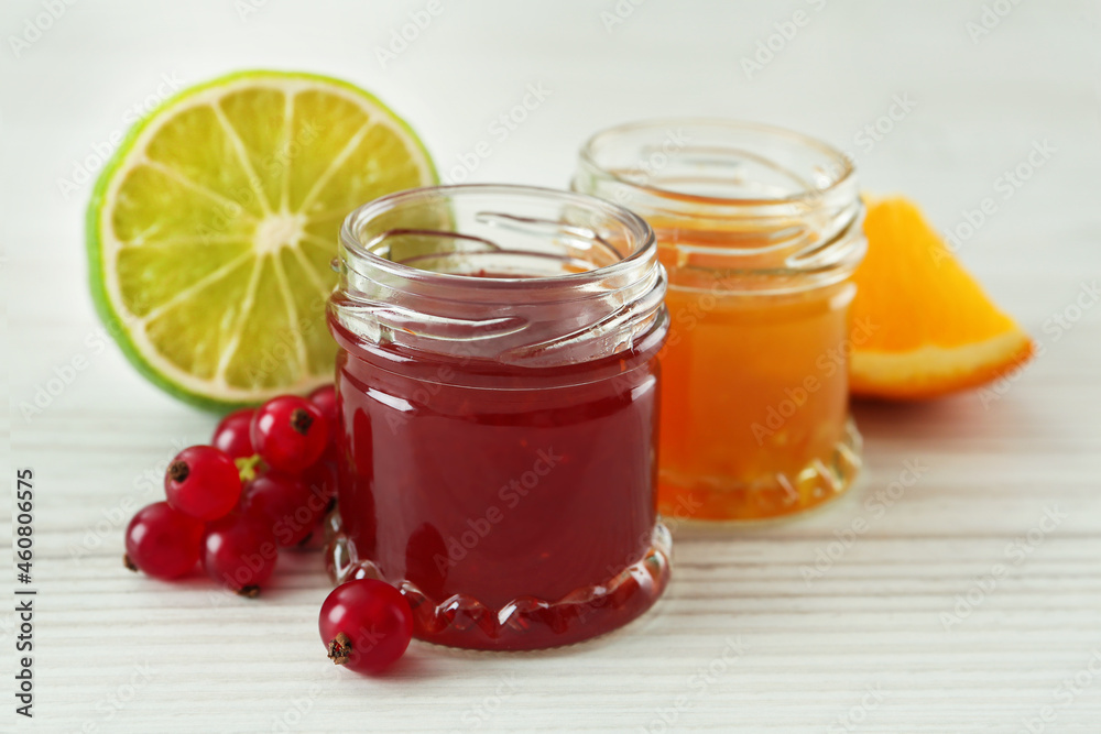 Jars of sweet red currant and citrus jams on white wooden table Jars of sweet red currant and citrus jams on white wooden table