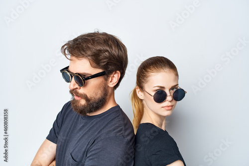 married couple in black t-shirt sunglasses posing light background