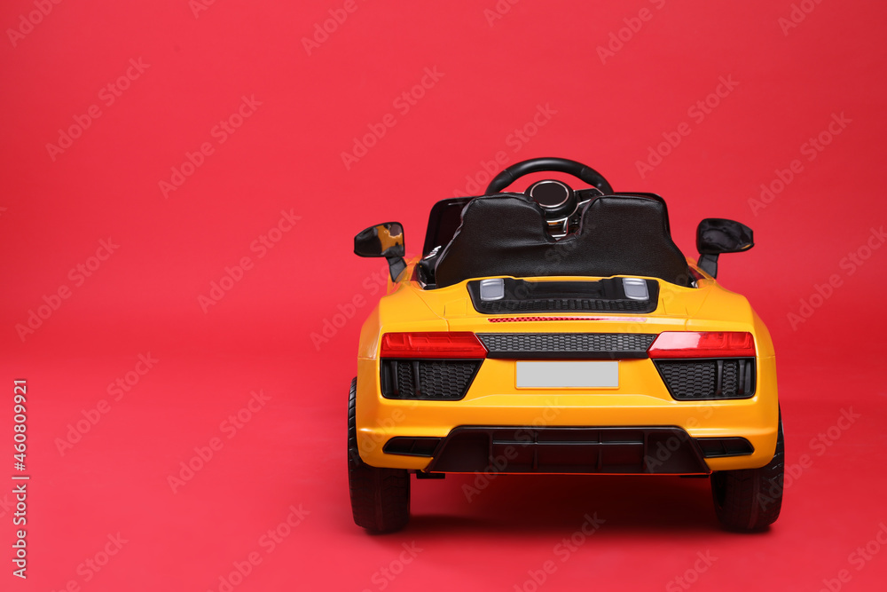 Child's electric toy car on red background. Space for text Child's electric toy car on red background. Space for text