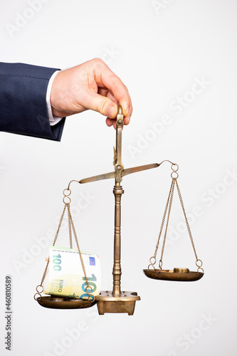 Money weighing on justice scale in business man hand. Payment balance and tax