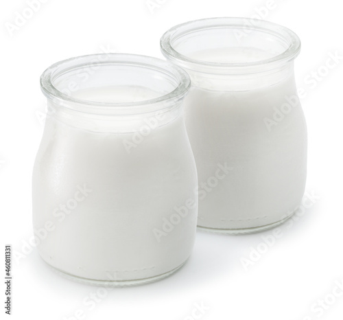 Two glass containers with plain yoghurt isolated on white background.