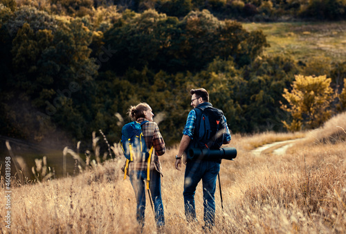 Couple with backpacks hiking together in nature on autumn day. © Zoran Zeremski
