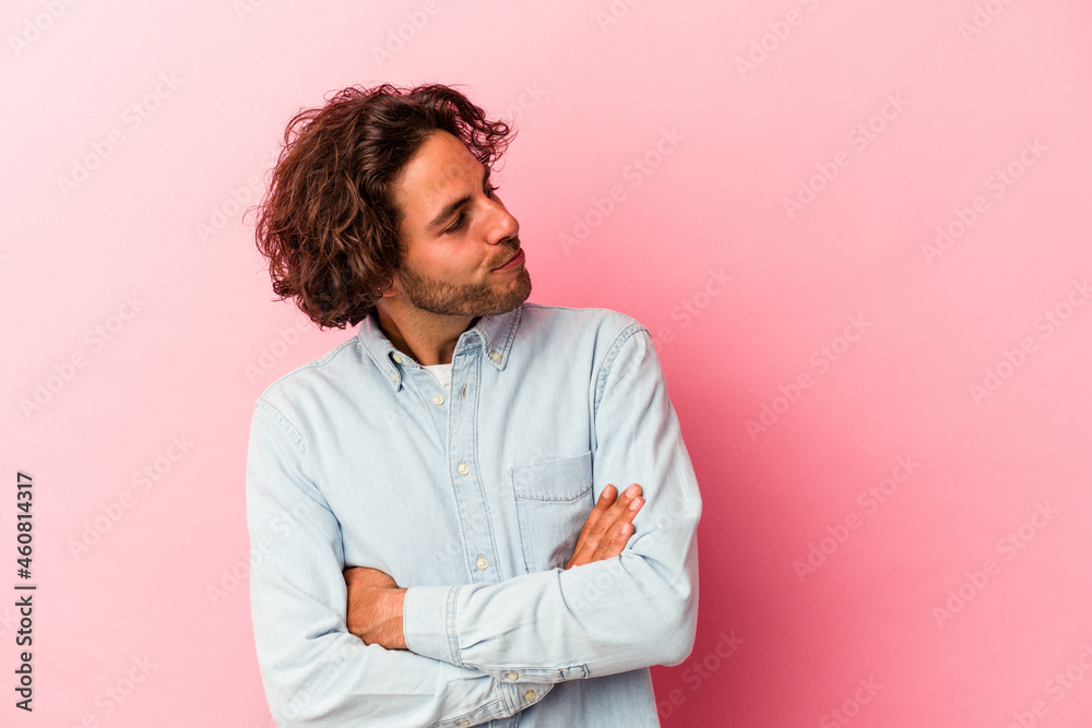 Young caucasian man isolated on pink bakcground dreaming of achieving goals and purposes