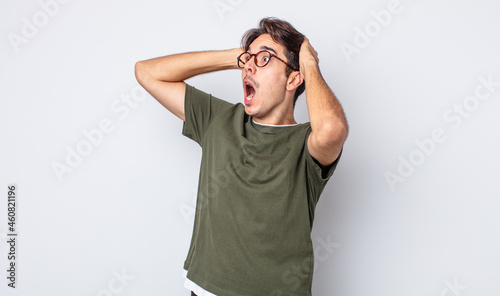 Fotografie young handsome hispanic man with open mouth, looking horrified and shocked becau