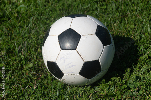 Practice soccer ball sits on sideline while game is underway.