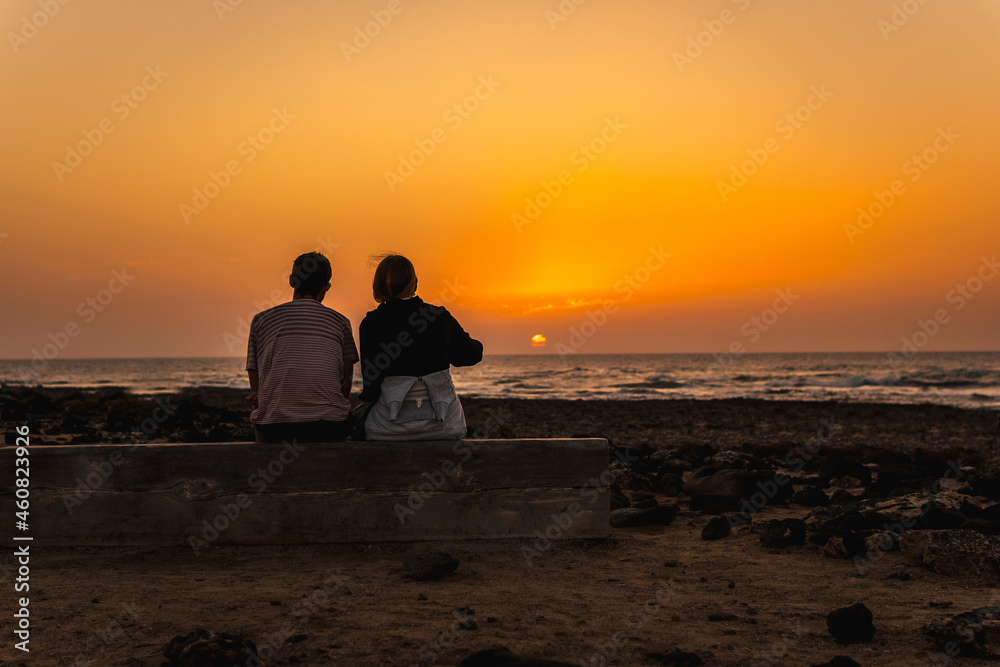 Silhouette of a couple at the Toston Lighthouse Sunset, Punta Ballena near the town of El Cotillo, Fuerteventura island, Canary Islands. Spain