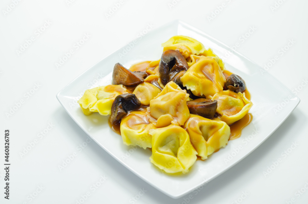 Fresh egg pasta with ricotta cheese and porcini mushrooms paste filling, delicious tortelloni Fresh egg pasta with ricotta cheese and porcini mushrooms paste filling, delicious tortelloni