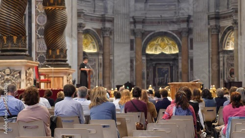 People listen to priest at catholic cathedral