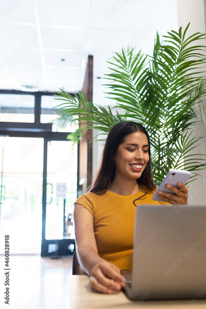 Smiling woman on smartphone and using laptop Smiling woman on smartphone and using laptop