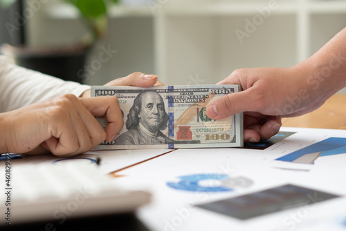 Businessman giving or paying money, US dollar bills