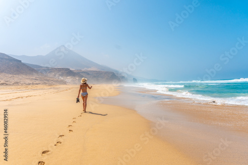 A young tourist walking alone on the wild beach Cofete in the natural park of Jandia, Barlovento coast, south of Fuerteventura, Canary Islands. Spain photo
