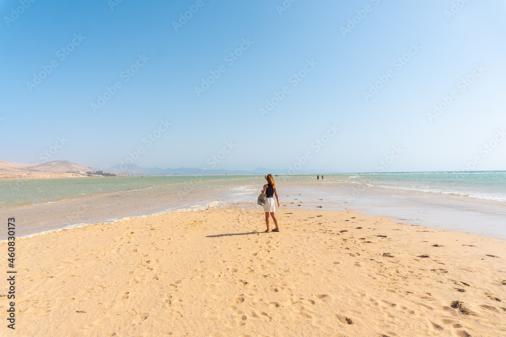 A young tourist walking along the Sotavento beach one autumn morning in the south of Fuerteventura, Canary Islands. Spain