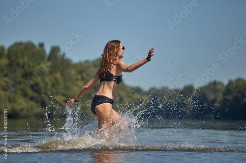 Girl at the beach running into the water