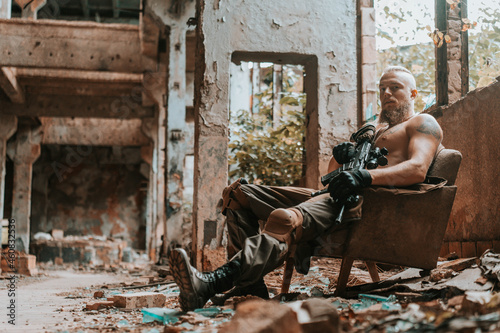 a man in a military uniform with a machine gun in an old destroyed building