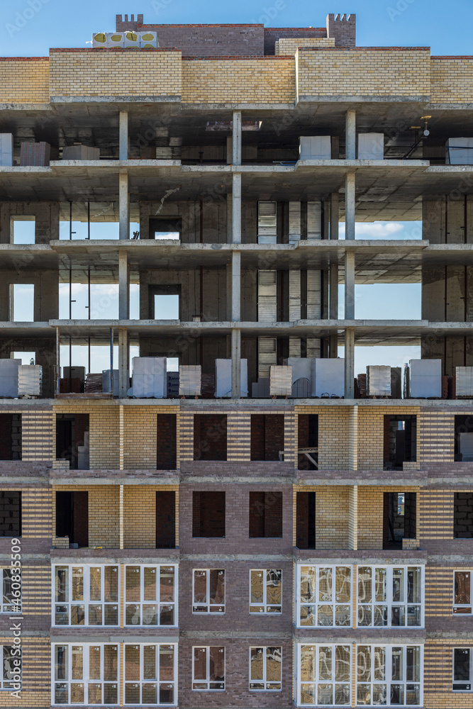The last floors of a building under construction. Construction of a residential complex. Frame of an unfinished real estate with balconies on a background of blue sky. The last floors of a building under construction. Construction of a residential complex. Frame of an unfinished real estate with balconies on a background of blue sky.