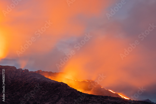 Night volcanic eruption. Fresh hot lava, flames and poisonous gases going out from the crater.