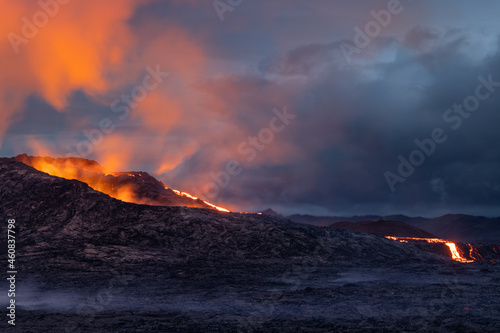 Night volcanic eruption. Fresh hot lava  flames and poisonous gases going out from the crater.