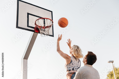 summer holidays, sport and people concept - happy young couple with ball playing on basketball playground © Syda Productions