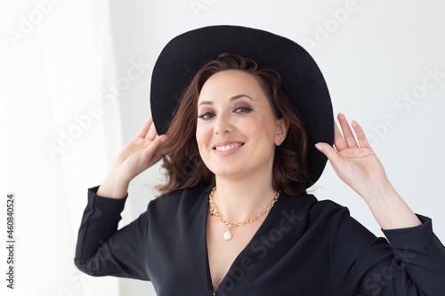 Portrait of a beautiful graceful woman in elegant hat with a wide brim. Beauty and fashion concept.