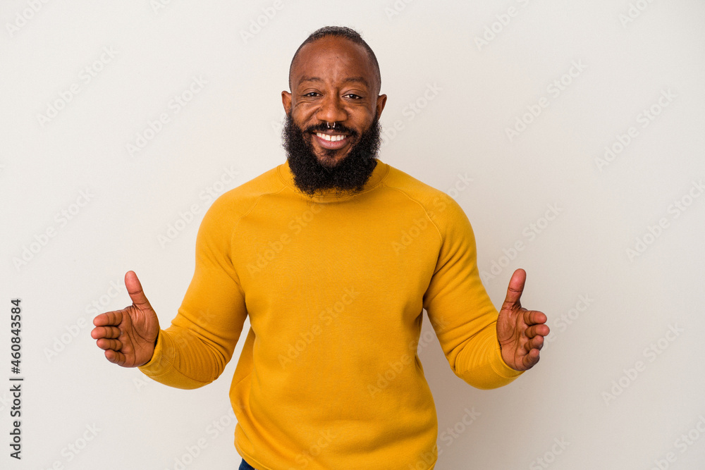 African american man with beard isolated on pink background holding something with both hands, product presentation. African american man with beard isolated on pink background holding something with both hands, product presentation.