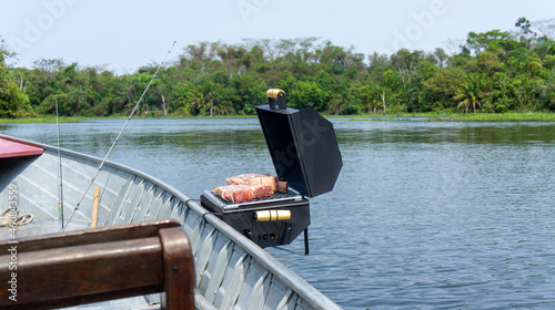 small barbecue grill on an aluminum fishing boat. On the Paraná River in Presidente Epitácio, São Paulo. photo