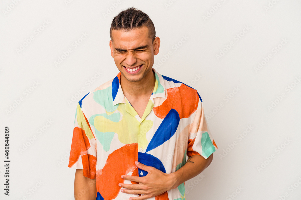 Young venezuelan man isolated on white background laughs and closes eyes, feels relaxed and happy. Young venezuelan man isolated on white background laughs and closes eyes, feels relaxed and happy.