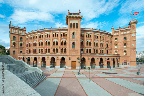 Front view of the Las Ventas bullring in Madrid one day with a blue sky and the flag of Madrid blowing in the wind photo